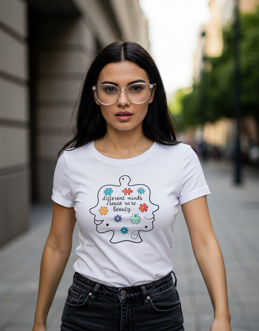 A white t-shirt with two outline faces, different and colorful puzzle pieces, and the slogan: different minds create rare Beauty.