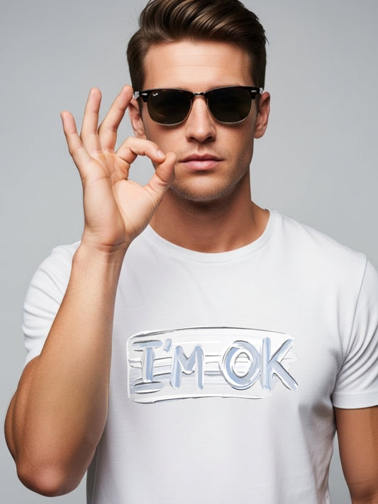 Man wearing sunglasses and a white t-shirt with 'I'm OK' text on a gray background