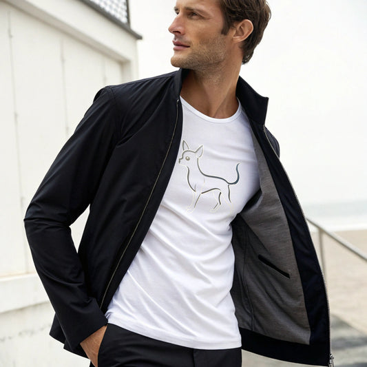 Man wearing a black jacket over a white t-shirt with a dog graphic, standing outdoors.